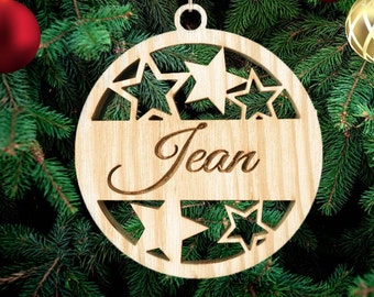 Puede incluir: Un adorno navideño de madera con un diseño de estrellas recortadas y el nombre "Jean" inscrito en él.