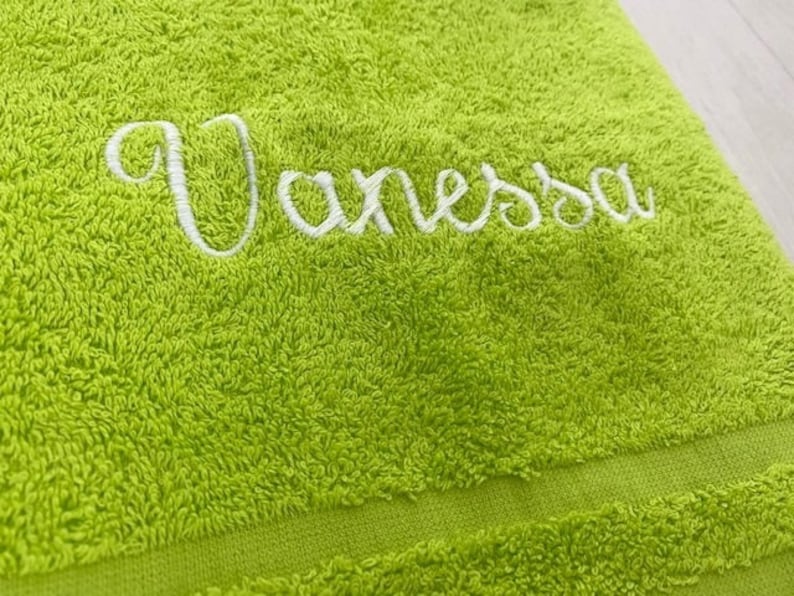 Pu&ograve; includere: Un asciugamano verde brillante con il nome "Vanessa" ricamato in bianco.