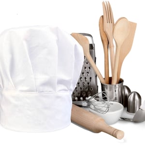 May include: A white chef's hat, a wooden rolling pin, a metal grater, a white ceramic bowl, a whisk, a set of wooden spoons, and a metal salt and pepper shaker set.