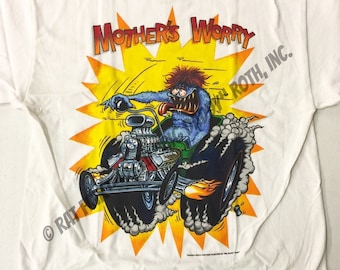 Könnte beinhalten: Weißes T-Shirt mit einem Cartoon-Monster, das einen Hot Rod fährt. Das Monster ist blau mit roten Augen und einer herausgestreckten Zunge. Der Hot Rod ist grün und hat Flammen, die aus dem Heck kommen. Der Text "Mother's Worry" befindet sich über dem Monster und der Text "Roth, Inc." rechts neben dem Monster.