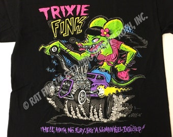 Può includere: Maglietta nera con un mostro di cartone animato verde che guida un hot rod. Il mostro è una donna con i capelli rosa e una camicia a righe rosa e bianche. Il testo "TRIXIE FINK" è stampato in rosa e giallo sulla maglietta. Il testo "HELL MATH. NO FURY LIKE A WOMAN FUEL-INJECTED!" è stampato in viola sulla maglietta. Il testo "RAT FINK PRODUCTIONS, INC." è stampato in bianco sulla maglietta.