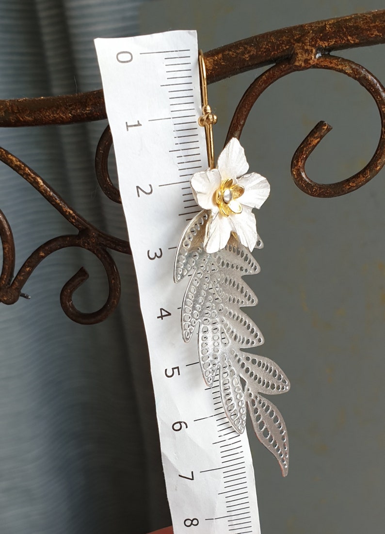 Long silver branch with a white flower