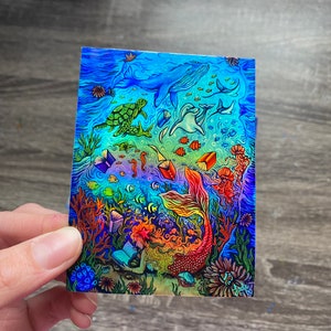 Érase una pegatina holográfica de Mermom