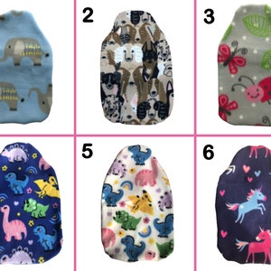 May include: Six different fabric hot water bottle covers. The covers are in various colors and feature different patterns, including elephants, dogs, ladybugs, dinosaurs, and unicorns.