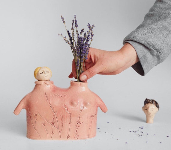 A handmade ceramic vase sculpted as an intertwined couple — it's romantic, one-of-a-kind, and genuinely useful as both sculpture and vessel.