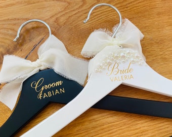 Personalized bride and groom hangers with pearl embellishment and chiffon bow