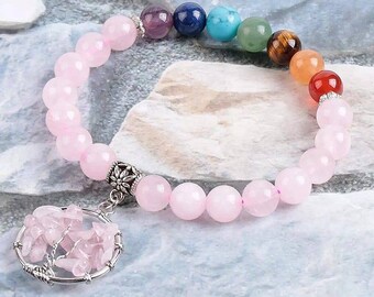 May include: A pink rose quartz bracelet with a silver tree of life charm. The bracelet features seven chakra beads in rainbow colors.