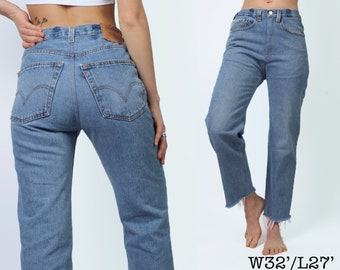 May include: Light blue denim jeans with a classic five-pocket design. The jeans have a straight leg fit and a raw, frayed hem. The waist size is W32, and the inseam is L27.