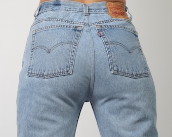 May include: A pair of light blue denim jeans with a Levi's patch on the back pocket. The jeans have a high waist and a straight leg.