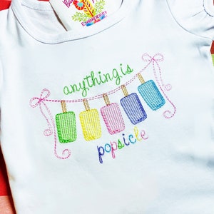May include: White baby onesie with colorful embroidered popsicles and the text "anything is popsicle".