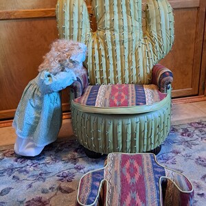 K&ouml;nnte beinhalten: Ein gr&uuml;ner Kaktus-f&ouml;rmiger Stuhl mit einem Kissen im S&uuml;dwest-Muster und einem passenden Fu&szlig;hocker. Der Stuhl hat eine wei&szlig;e Blume oben und der Fu&szlig;hocker hat ein &auml;hnliches Muster wie das Kissen.