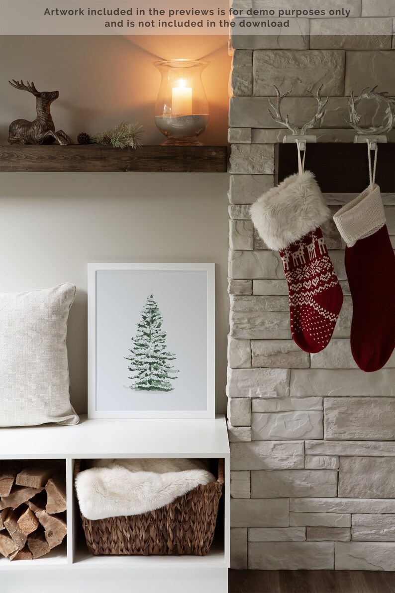 May include: A white shelf with a framed watercolour painting of a green pine tree. The shelf is above a white storage bench with a wicker basket filled with a white faux fur throw. The bench is in front of a stone fireplace with two red and white knitted stockings hanging from hooks.