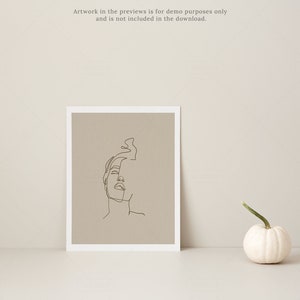 May include: A framed art print featuring a minimalist line drawing of a face, set against a neutral background. A small white pumpkin with a green stem sits nearby. The text "Artwork in the previews is for demo purposes only and is not included in the download." is visible.