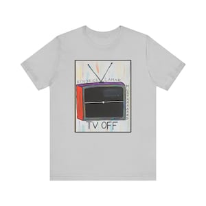 May include: A light gray t-shirt with a colorful illustration of a television set with the text "KENDRICK LAMAR MUSTARD" and "TV OFF" printed on the front.