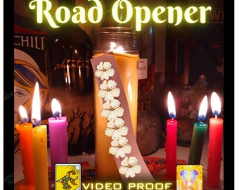 May include: A collection of lit candles in various colours including orange, yellow, purple, red, and green, surrounding a central pillar candle. A vertical strip with white flower illustrations is placed on the pillar candle. Text reads Road Opener and VIDEO PROOF, with The Fool and Opportunity tarot cards visible.