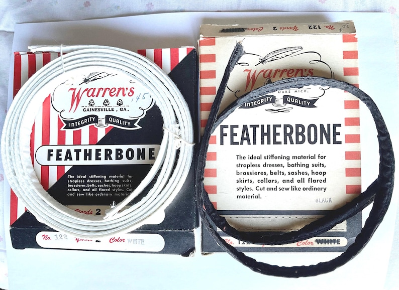 May include: Two spools of white Featherbone stiffening material for clothing. The spools are labeled "Warren's" and "Featherbone". The text on the spools reads "The ideal stiffening material for strapless dresses, bathing suits, brassieres, belts, sashes, hoop skirts, collars, and all flared styles. Cut and sew like ordinary material."