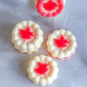 May include: Four white and red Canadian themed soap bars with a maple leaf design.