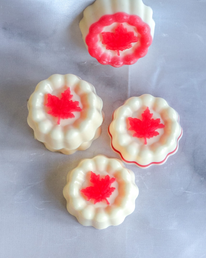May include: Four white and red Canadian themed soap bars with a maple leaf design.