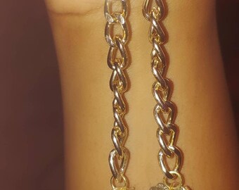 May include: A pair of gold chain earrings with a raw pyrite stone wrapped in wire at the end of each chain.