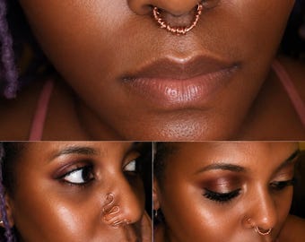 May include: A copper wire septum ring featuring a textured, wrapped design. The jewelry is shown in three views, including a close-up of the septum placement and a side profile view showing the wavy, continuous wire structure of the nose ring.