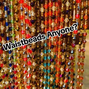 May include: A collection of colorful waist beads made with glass beads in various colors, including gold, red, blue, green, and clear. The beads are strung on a thin cord and are arranged in a cascading pattern. The text "Waistbeads Anyone?" is visible in the image.