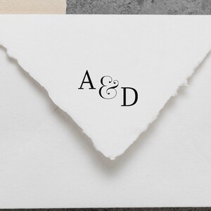May include: White envelope with a black ink stamp that says "A&D" in a cursive font.