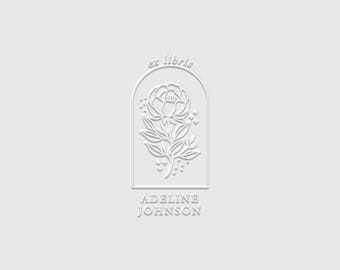 May include: A white embossed graphic design featuring an arched frame containing a floral illustration of a peony. The text ex libris is positioned above the flower, and the name ADELINE JOHNSON is printed in capital letters below the arch.