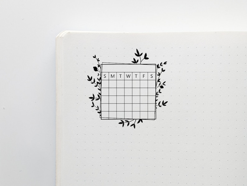 May include: A black and white weekly calendar planner with a floral design. The calendar has the days of the week labeled S, M, T, W, T, F, S.