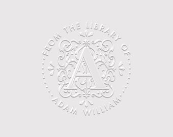 May include: A circular white embossed stamp design featuring a central letter A surrounded by intricate scrollwork. The text FROM THE LIBRARY OF is arched across the top, and the name ADAM WILLIAM is arched across the bottom in capital letters.