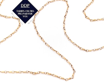 May include: A delicate gold-colored chain necklace with a repeating bar and link design. The necklace is displayed against a white background. A navy blue and white graphic with the text "DDP TARIFFS/DUTIES PRE-PAID FOR YOU" is in the upper left.