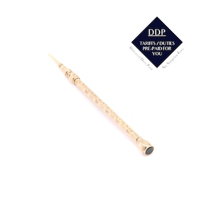 May include: A gold-colored, ornate, long, slender object with a small, dark-colored tip. The object has a textured surface with engraved details. The image also includes a blue diamond-shaped logo with the text "DDP TARIFFS/DUTIES PRE-PAID FOR YOU".