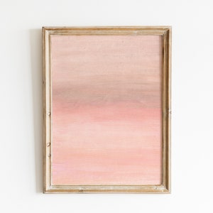 Puede incluir: Una pintura abstracta enmarcada con un degradado de color rosa, naranja y marrón. La pintura está en un marco de madera simple.