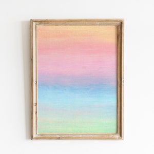 May include: A framed painting with a horizontal ombre design in shades of yellow, pink, blue, and green.