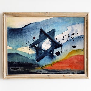 May include: A framed watercolor painting of a blue Star of David with a yellow, orange, and blue background. The date "7/10/2023" is written in the bottom left corner.