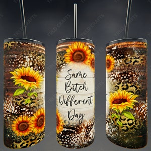 May include: A stainless steel tumbler with a rustic wood and leopard print design. It features sunflowers and the text "Same Bitch Different Day".