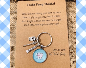 Lindo llavero con forma de diente, con dijes de pasta de dientes, cepillo de dientes e hilo dental. Regalo ideal para el hada de los dientes o el dentista.