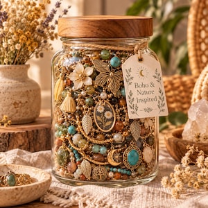 May include: A clear glass jar with a wooden lid filled with assorted jewelry including gold-tone chains, turquoise beads, leaf charms, a butterfly pendant, and a floral oval charm. A tag attached to the jar reads Boho & Nature Inspired.