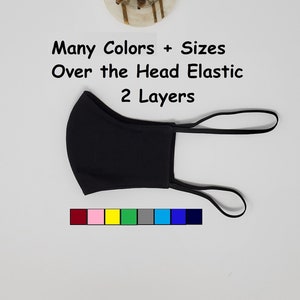 May include: Black face mask with over the head elastic straps. The mask is made of two layers of fabric. The text "Many Colors + Sizes Over the Head Elastic 2 Layers" is written below the mask. A color chart with 10 different colors is shown below the text.