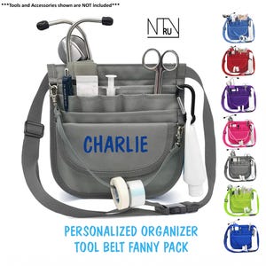 Puede incluir: Ri&ntilde;onera organizadora de herramientas gris personalizada con el nombre "CHARLIE" en azul. El organizador tiene m&uacute;ltiples bolsillos, una correa para el hombro y un mosquet&oacute;n negro. Se muestran opciones de color adicionales.