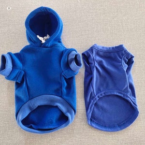 Op de afbeelding: Twee blauwe hondenshirts, een is een hoodie en de andere is een t-shirt.