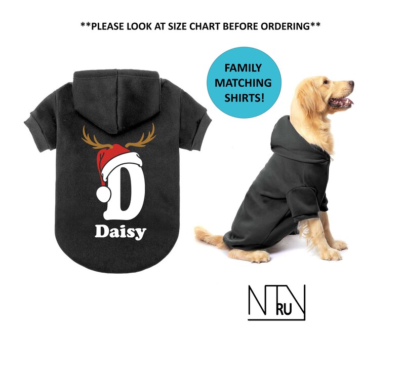 May include: Black hooded dog sweatshirt with a reindeer antler and Santa hat design, the letter "D", and the name "Daisy". A dog wears a matching black hoodie. Text: "Family Matching Shirts!"