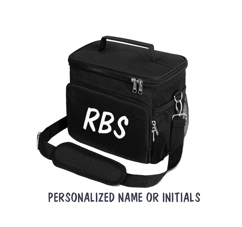 Puede incluir: Bolsa de almuerzo aislada negra con una correa para el hombro y un asa superior. La bolsa tiene un cierre de cremallera y un bolsillo lateral de malla. Las iniciales "RBS" est&aacute;n impresas en blanco en la parte delantera de la bolsa.