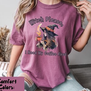 以下が含まれることがあります： コーヒーカップを持った魔女のグラフィックが描かれたパープルのTシャツ。シャツのテキストは「ウィッチプリーズ、アイニードマイコーヒーファースト」です。