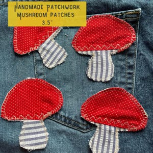 May include: Four handmade patchwork mushroom patches in red and white fabric, sewn onto a blue denim background. The patches are approximately 3.5 inches in size.  HANDMADE PATCHWORK MUSHROOM PATCHES 3.5" is written in yellow text at the top of the image.