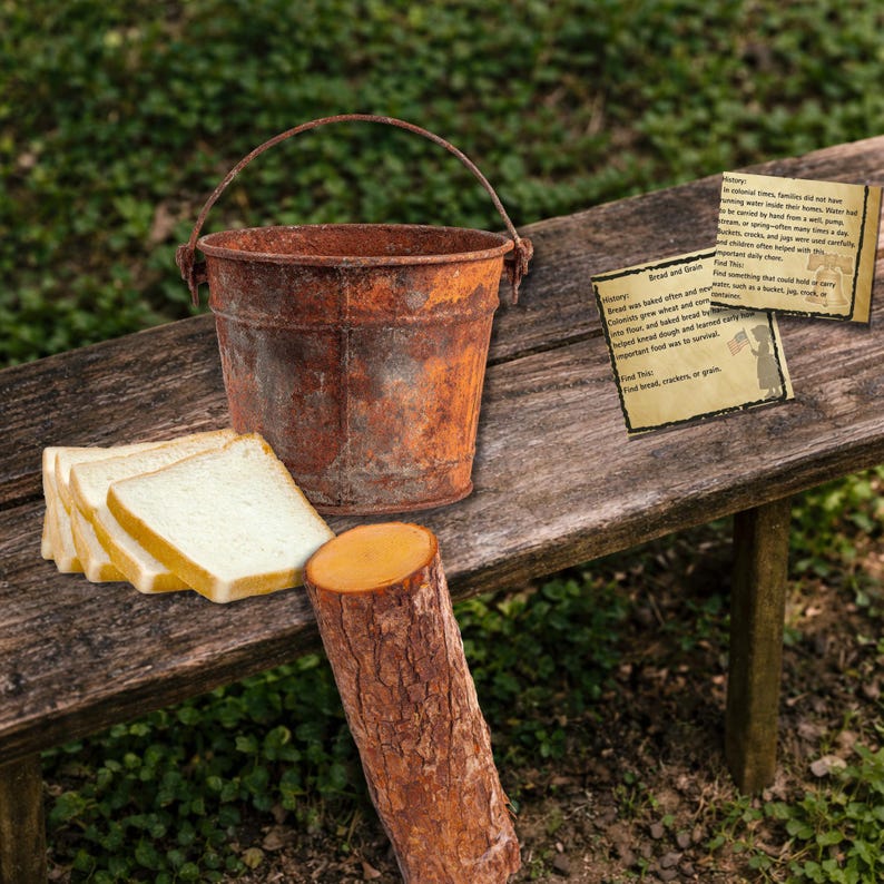 May include: A rusty metal bucket with a handle sits on a wooden bench next to slices of white bread and a small log. Two informational cards are also on the bench, with text about bread and grain.