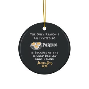 May include: A black and white round Christmas ornament with the text "The only reason I am invited to parties is because of the wicked deviled eggs I make Jennifer 2024". The ornament features a plate of deviled eggs.