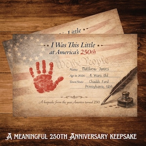 Op de afbeelding: Een rechthoekige aandenkenkaart met een vervaagde Amerikaanse vlag op de achtergrond, een rode handafdruk, een ganzenveer en een inktpot. De tekst bevat: I Was This Little at America's 250th, We the People, Name: Matthew James, Age in 2026: 4 Years Old.