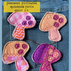 May include: Four handmade patchwork mushroom patches in pink, orange, purple, and gold fabrics. The patches are about 3.5 inches in size and are sewn with pink thread. "HANDMADE PATCHWORK MUSHROOM PATCH ABOUT 3.5" is written on a yellow background.