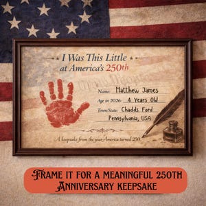 Op de afbeelding: Een ingelijst herdenkingsdocument met een rode handafdruk, een ganzenveer en een inktpot. De tekst luidt: I Was This Little at America's 250th, Name: Matthew James, Age in 2026: 4 Years Old, Town/State: Chadds Ford, Pennsylvania, USA, A keepsake from the year America turned 250.