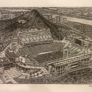 Op de afbeelding: Een zwart-witte pen-en-inkt tekening van een voetbalstadion. Het stadion is omgeven door een stad en een rivier. De tekening is gesigneerd met "Nick Van Vliet".